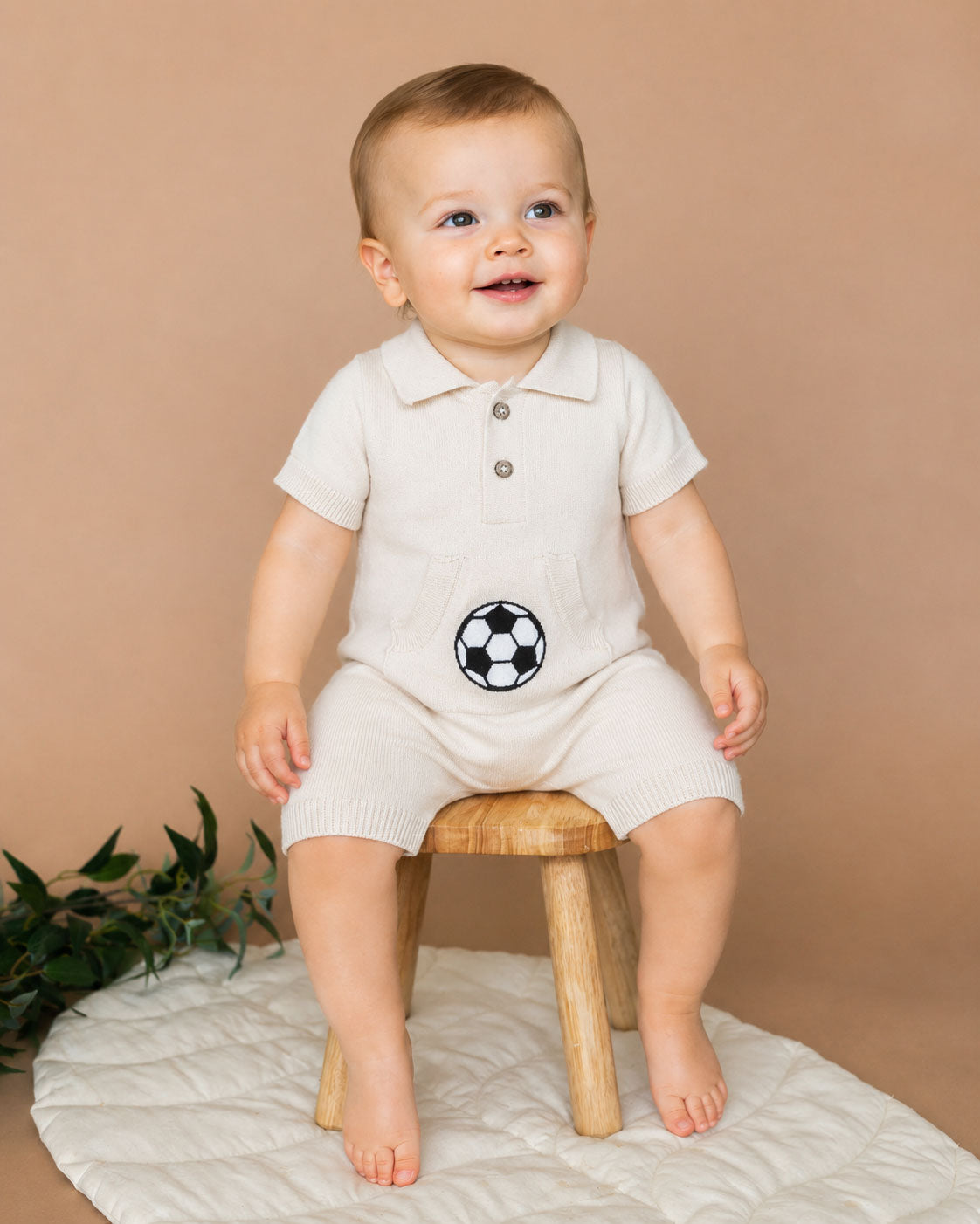 Baby wearing Soccer Applique Baby Knit Romper in soft organic cotton