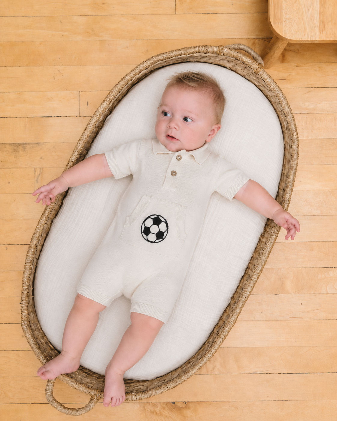 Baby in basket wearing Soccer Applique Baby Knit Romper made with organic cotton