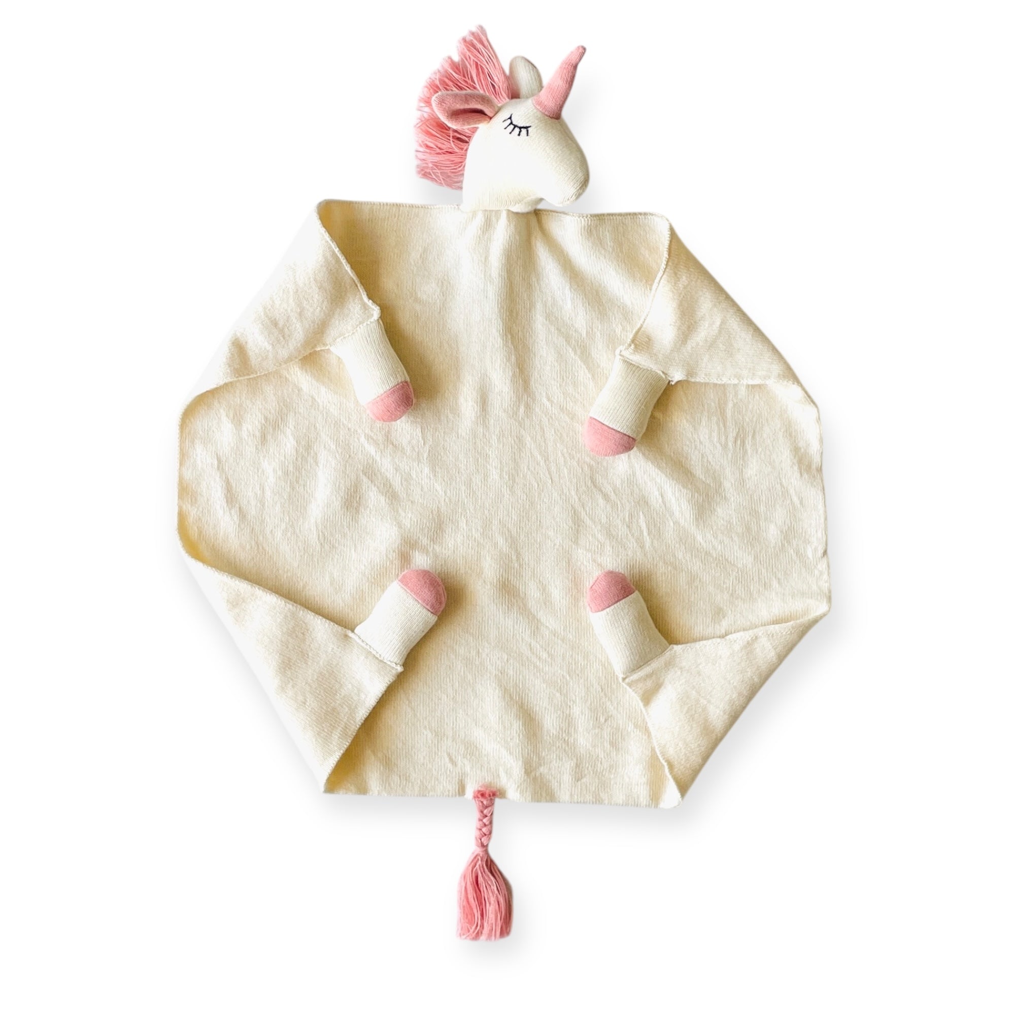 Unicorn-shaped plush toy with a blanket on a white background
