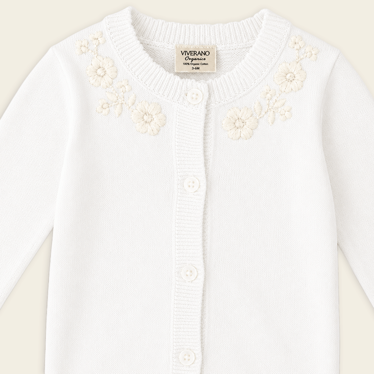 detail  of dove white floral embroidered knit baby jumpsuit made with organic cotton